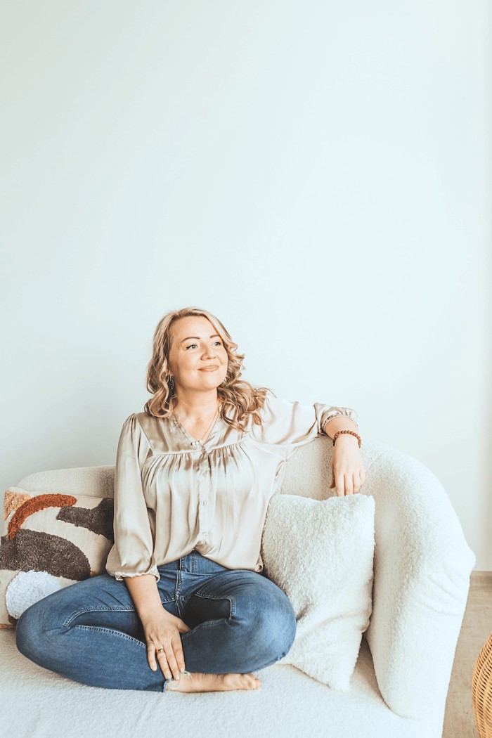 Happy woman sitting on couch, feeling clear after assessment results